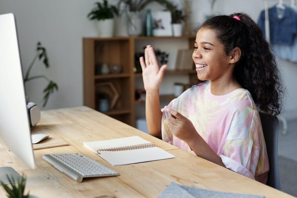 Menina sinalizando para WebCan durante aula online 